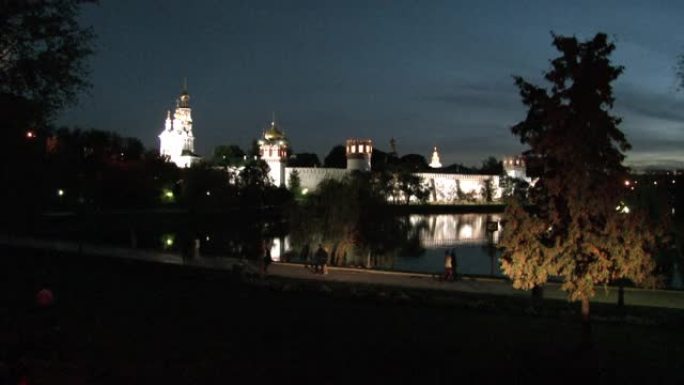 晚上，人们在池塘岸边的Novodevichy修道院附近行走。