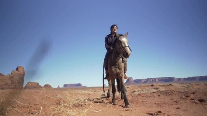 纳瓦霍少年在亚利桑那州纪念碑谷骑马