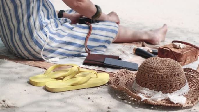 在暑假期间，关闭快乐的亚洲妇女听音乐并在海滩上放松身心。社交数字排毒