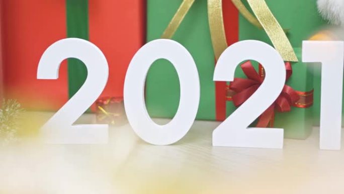 2021新年模型幻灯片拍摄。许多色彩鲜艳的礼物礼盒和装饰，带有金色闪闪发光的bokeh前景。圣诞快乐