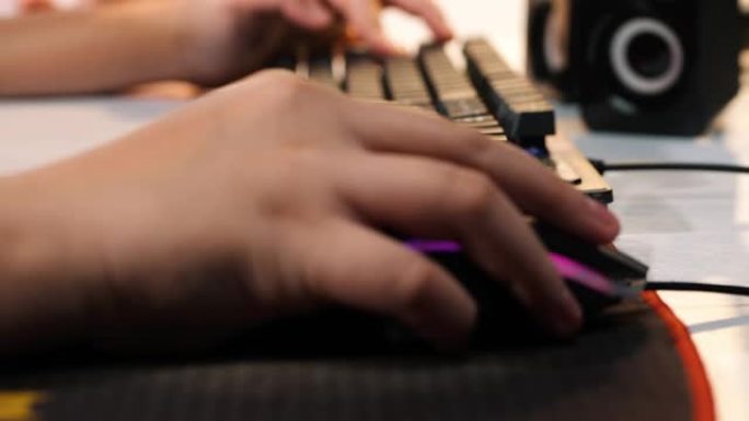 孩子的手用电脑在家玩网络游戏，生活方式概念。