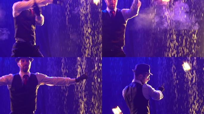 时尚的男人用链子上的发光和吸烟球表演火把戏。艺术家在蓝色烟熏工作室背景下的雨水中表演。消防和水上表演