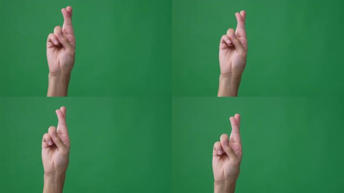 手指交叉在绿色屏幕上的手