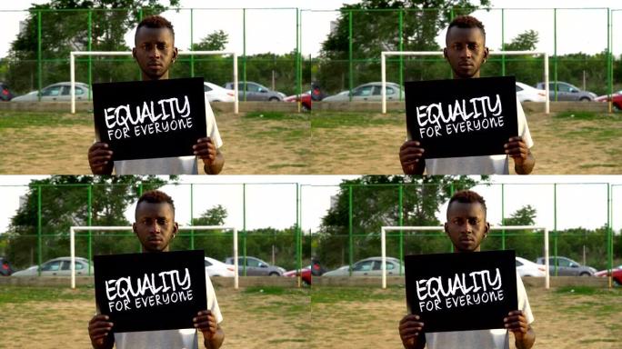 非洲青年抗议者手持纸板“人人平等”