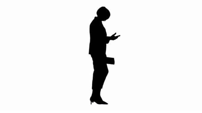 剪影优雅的高级女性走路时使用智能手机