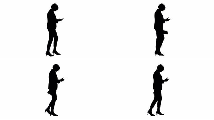 剪影优雅的高级女性走路时使用智能手机