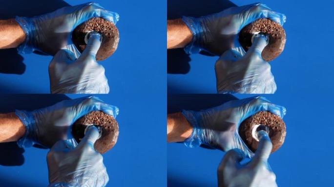 医生泌尿科医生在医用手套做前列腺按摩。泌尿外科男性性健康概念。用奶油润滑将手指浸入甜甜圈孔中。前列腺