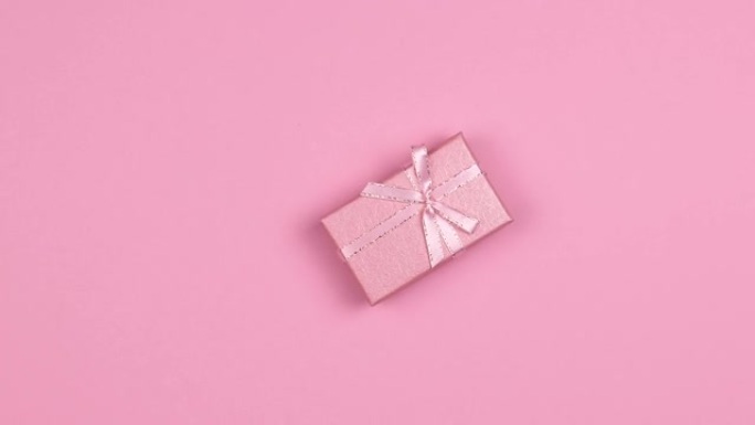长方形礼品盒，带丝带和蝴蝶结旋转特写，粉色背景，无缝循环运动
