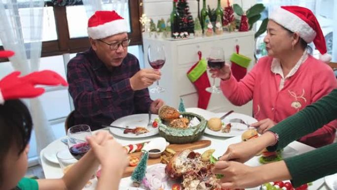 感恩节或圣诞节庆祝亚洲家庭晚餐概念。家庭有假日晚餐。快乐的家庭为聚会做饭。父亲母亲和女儿，在家吃饭。