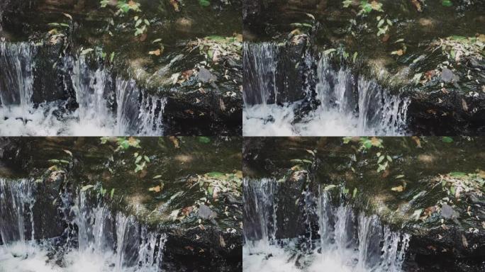 瀑布，水流过秋叶的石头，瀑布的镜头。