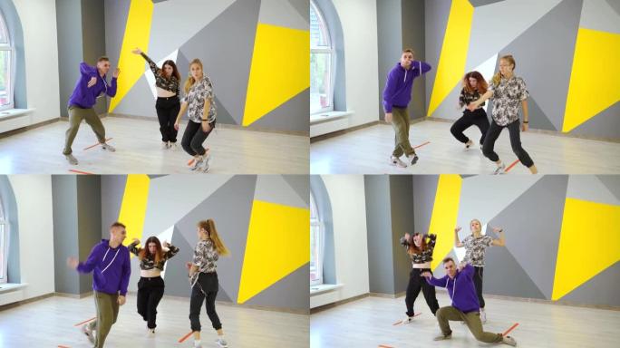 一男两女跳嘻哈，一种自由风格的青年当代舞蹈，在墙前的舞蹈工作室里有明亮的几何图案