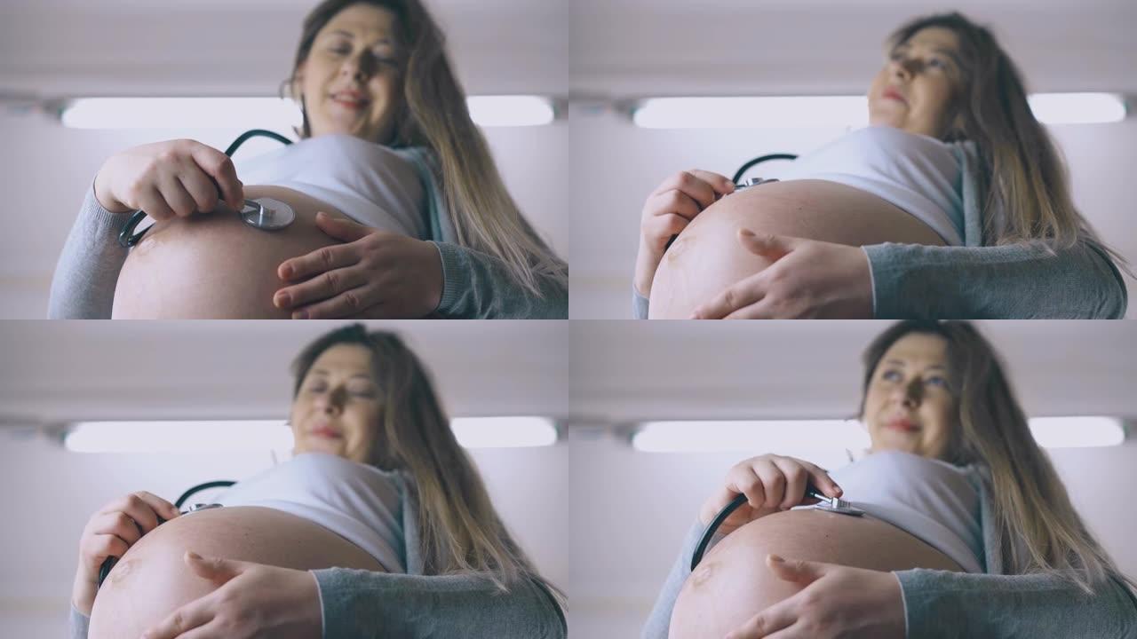孕妇在肚子上听诊器听婴儿