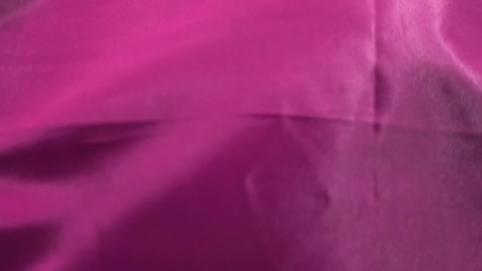 紫罗兰色粉红色纺织品在特写镜头和慢动作中在风中颤抖