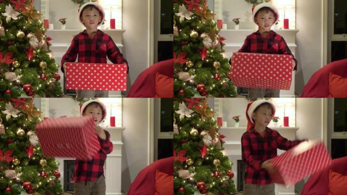 可爱的亚洲男孩唱一首歌，作为打开他的圣诞礼物的追求