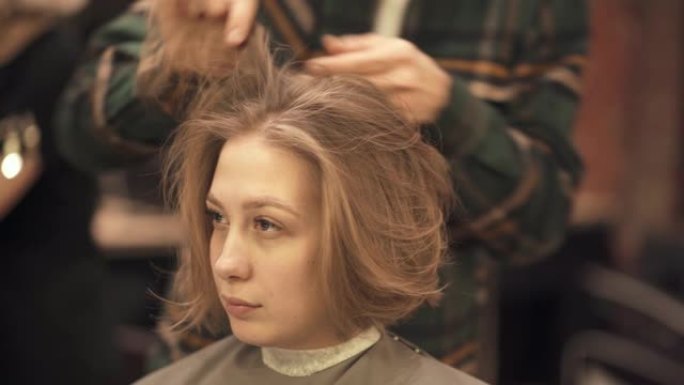 理发师在理发后用手为女性顾客定型头发