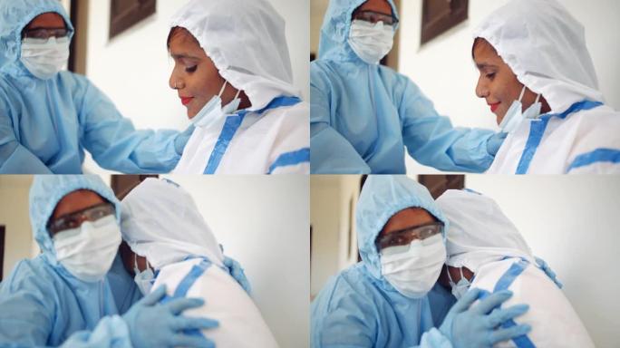 两名穿着PPE服的女医生精疲力尽，帮助邦德彼此分享