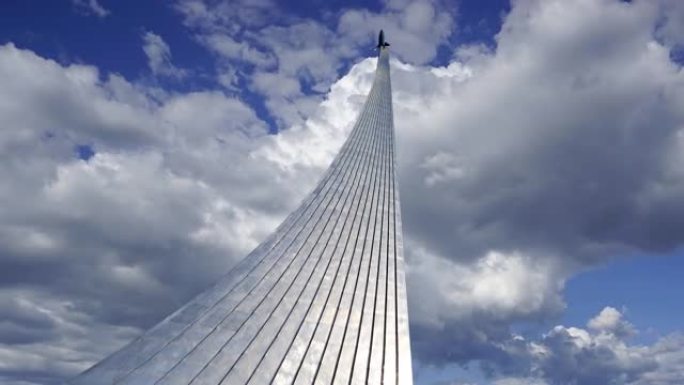 太空征服者纪念碑 (在移动的云层上) 在莫斯科VDNK展览中心附近的宇宙博物馆户外公园中