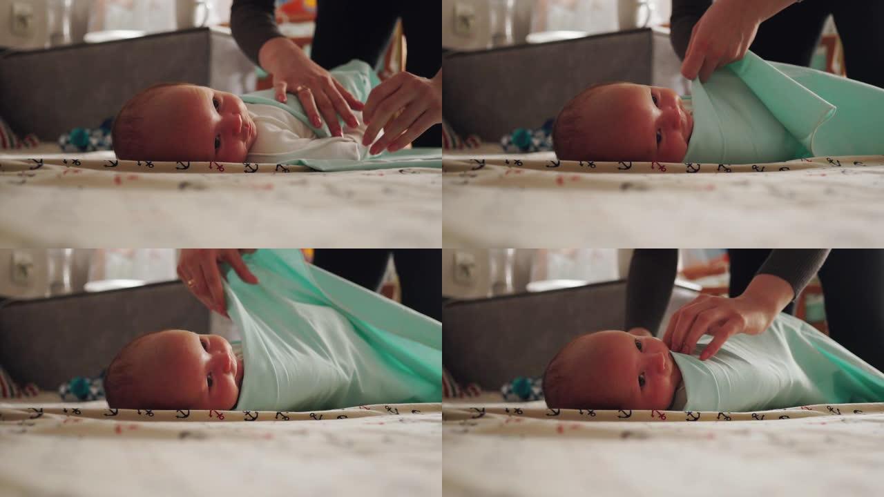 母亲襁褓着她刚出生的婴儿。把婴儿用尿布包起来。新生儿躺在床上