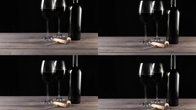 豪华红酒。两个酒杯，开瓶器，软木塞和一瓶红葡萄酒，由桌上的美味红葡萄制成，背景为黑色。慢动作。中枪。