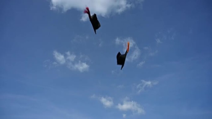 毕业生向天空扔上一顶黑帽子，以表达他们在大学毕业时的喜悦。