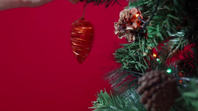 圣诞玩具的心脏挂在红色背景的圣诞树上特写