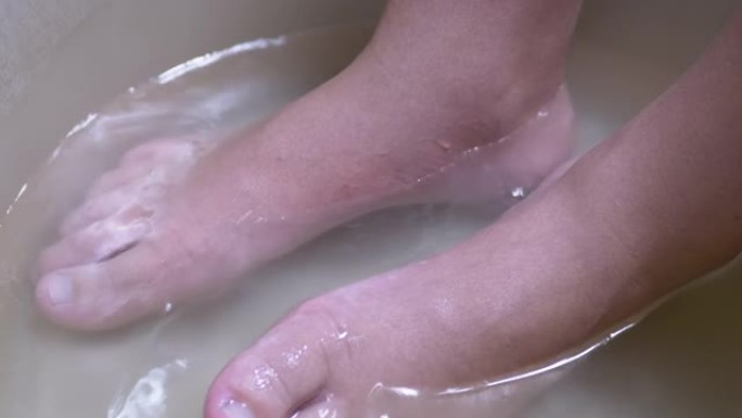 在盆里用热水洗孩子的腿。《洗脏脚》4K