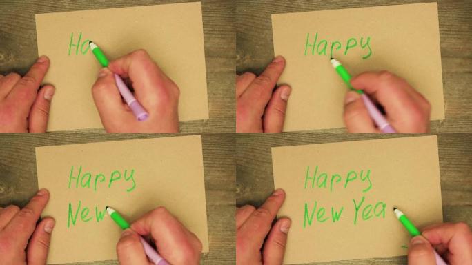 一只男性用绿色毡尖笔在纸板上写下新年快乐