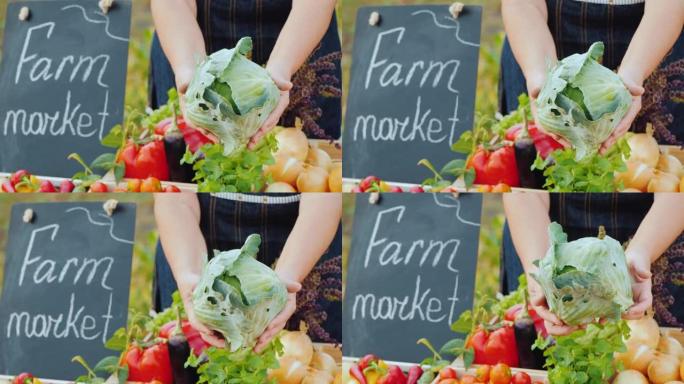 农夫的手和一头卷心菜放在柜台上。在农贸市场出售蔬菜