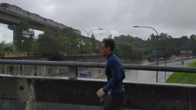 穿着运动服的亚洲华裔运动员在雨中在街上慢跑