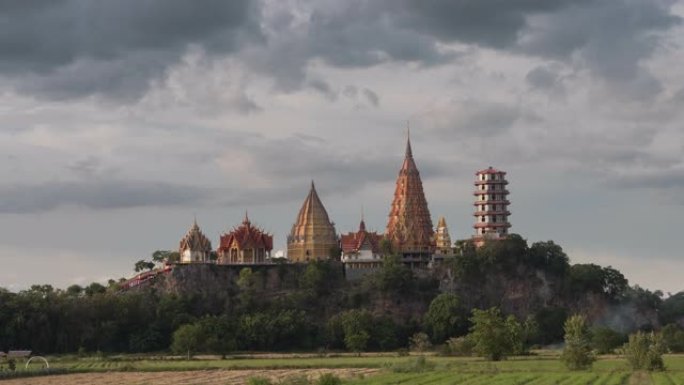 时光流逝的Wat tham sua或tiger cave temple，带有绿色的茉莉稻田，蓝天，阳