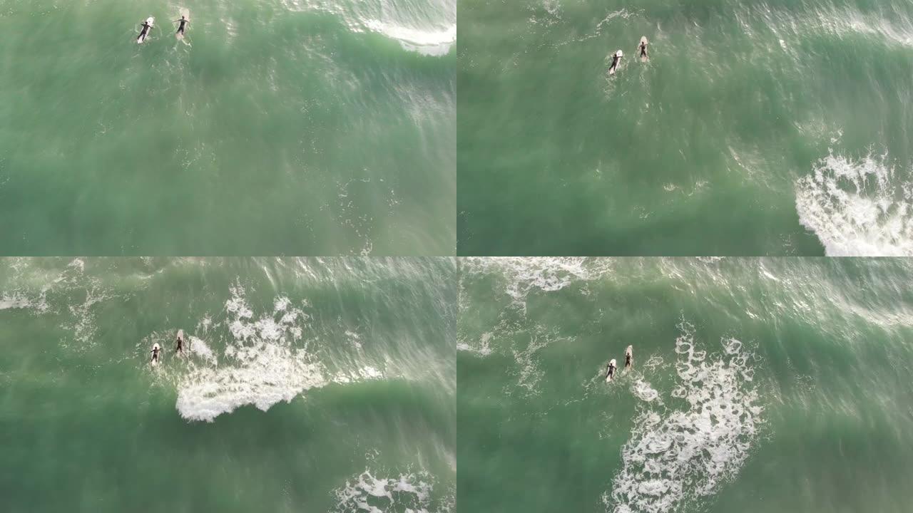 冲浪者面对着神奇的泡沫海浪和膨胀的翡翠色海洋之间的能量海洋