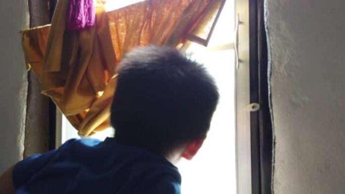 一个小男孩从窗户向外看