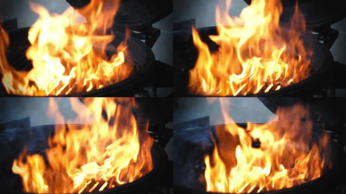烹饪。烹饪汉堡。特写视图。餐厅厨房的热明火烧烤架。慢动作中的火焰和烟雾。快餐、垃圾食品