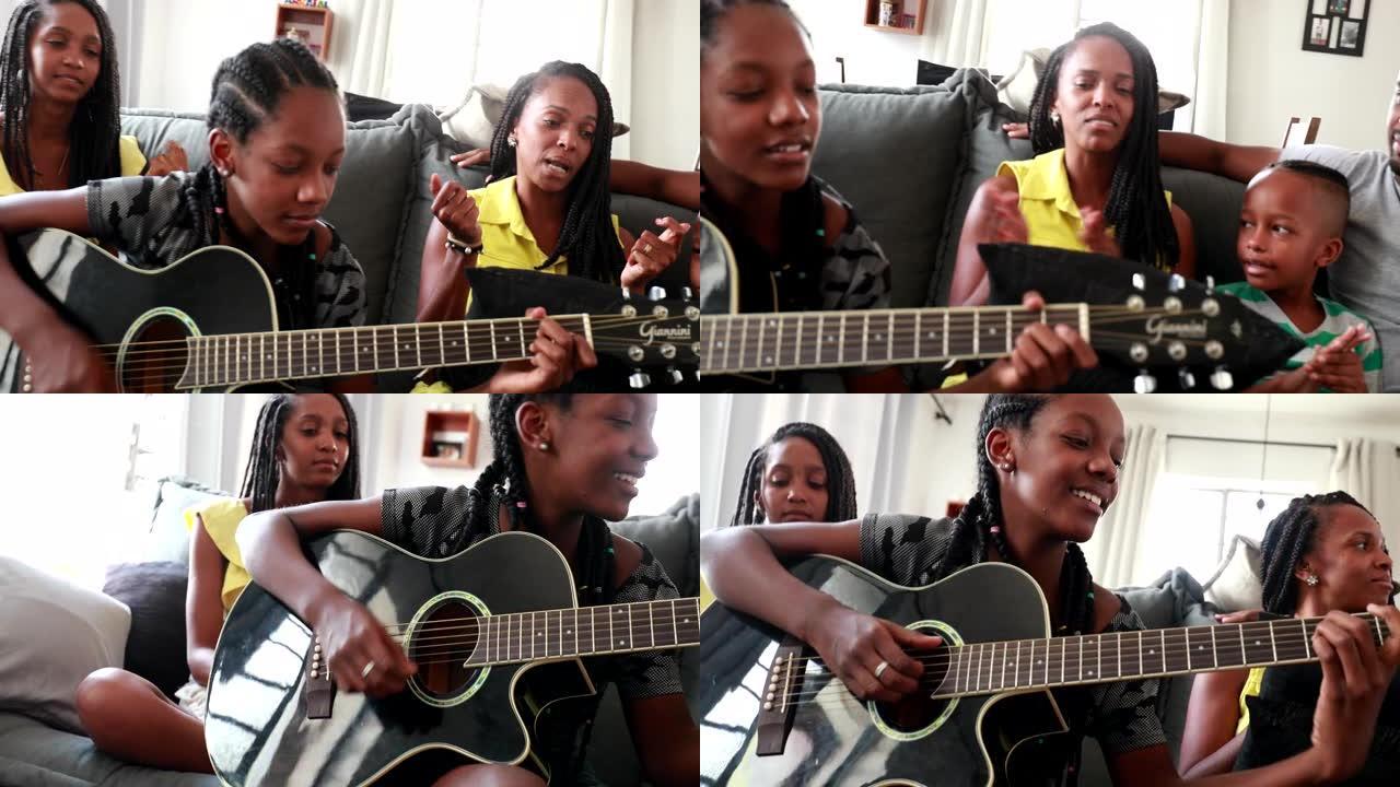 休闲的非洲家庭坐在家里的沙发上，黑人女儿演奏吉他器乐