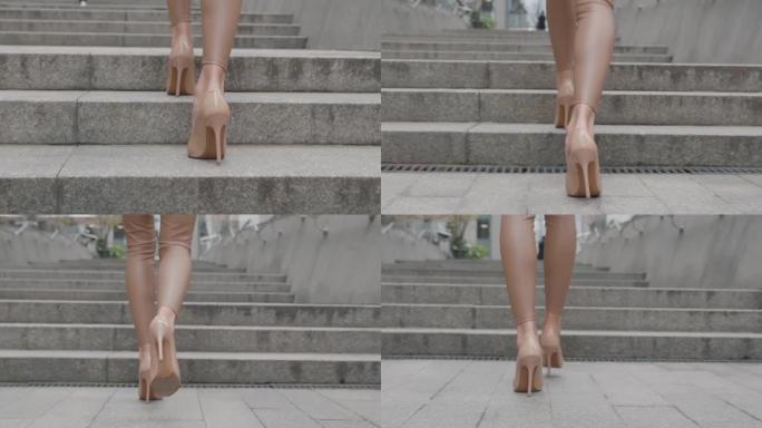 女商人高跟鞋上下班的后视脚 ..穿着高跟鞋的女性双腿在市区的城市街道上行走。