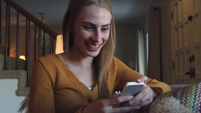 Z世代女性在家沙发上使用智能手机4k视频系列
