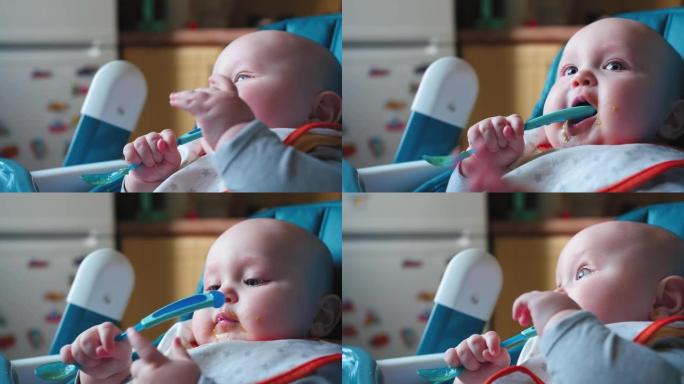 7个月大的婴儿坐在高脚椅上，拿一勺蔬菜。婴儿食品概念。特写镜头。