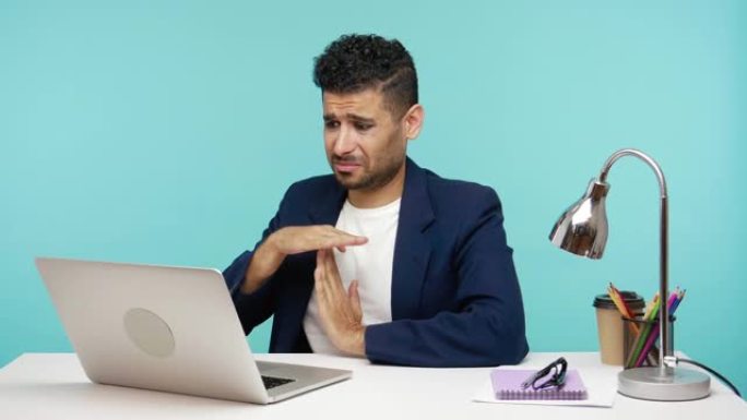 紧张不安的自由职业者在笔记本电脑的网络摄像头上展示了用手的时间，要求更多时间完成任务