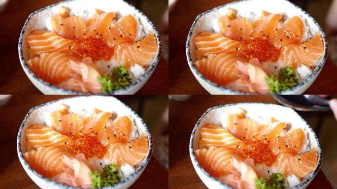 在饭碗中吃生鱼片三文鱼片配虾卵，生活方式概念。