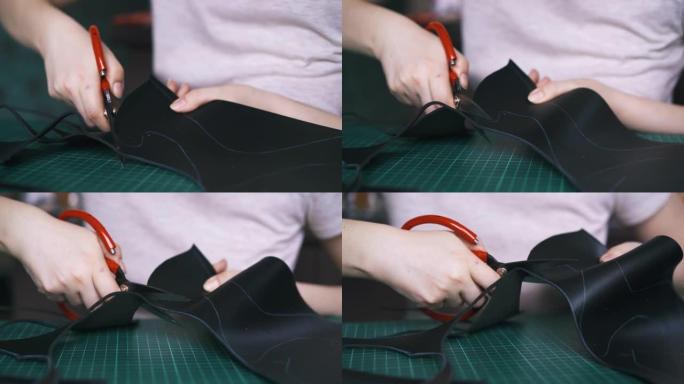 熟练的设计师切割黑色皮革制作面膜