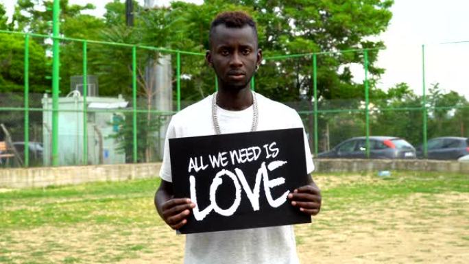 非洲青年抗议者手持纸板“我们需要的是爱”