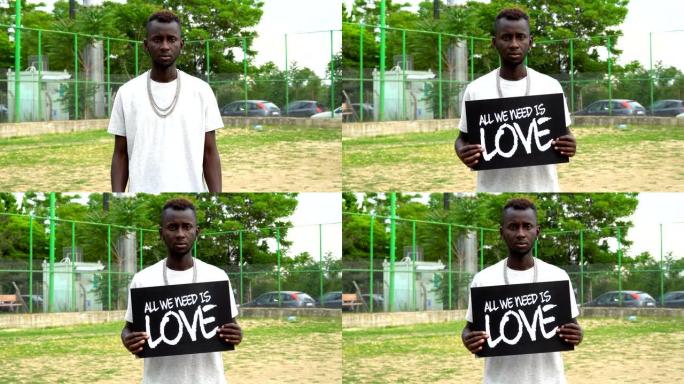 非洲青年抗议者手持纸板“我们需要的是爱”