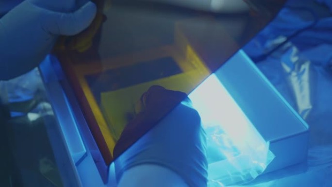 科学家在实验室的紫外线盒下切割凝胶中的DNA，科学家在实验室工作
