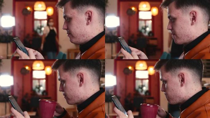 男人喝茶上网，使用电话。视觉上明显的皮肤状况