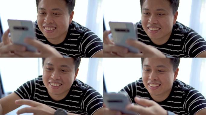 亚洲男子在家使用智能手机。