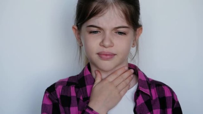 抱着喉咙痛的小女孩。心绞痛，扁桃体炎，咽炎，小儿感冒。