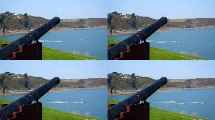 老式大炮和快艇俯瞰海湾