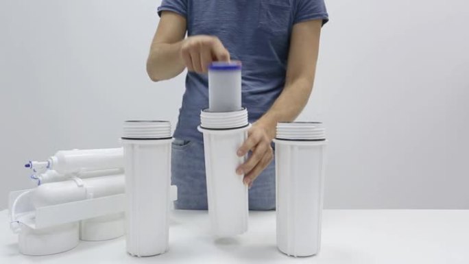 男性双手展示反渗透家用滤水器气缸内的碳部分透过膜滤筒