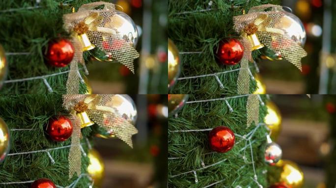 红色泡泡和金钟饰品挂在圣诞树上，节日概念。