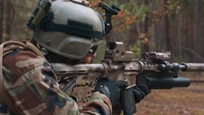 林中狙击兵穿着特殊军装、头上戴头盔、手持狙击步枪在森林中瞄准瞄准镜的士兵